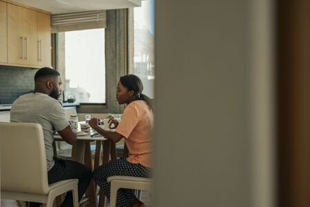 Young African American couple talking together over breakfastの写真素材