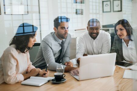 Diverse business colleagues working with a laptop in an officeの写真素材