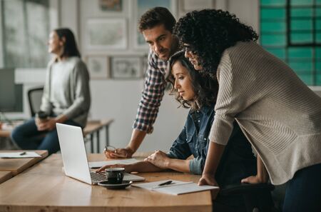 Diverse group of designers working together on an office laptopの写真素材