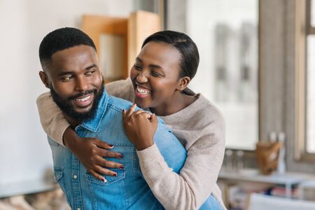 Playful young African American couple relaxing together at homeの写真素材