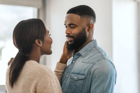 Romantic young African American couple standing lovingly together at homeの写真素材