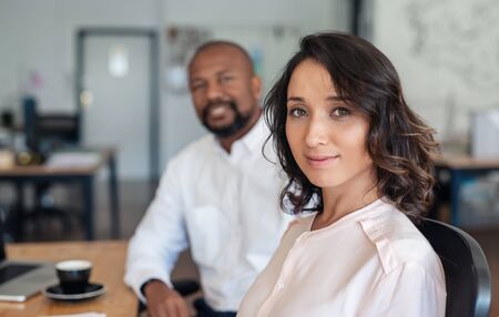 Young businesswoman sitting with a colleague in an officeの写真素材