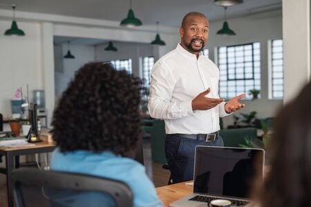 African American businessman meeting with his staff in an officeの写真素材