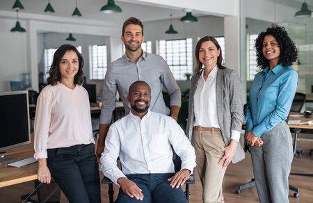 Diverse team of smiling businesspeople working in a modern officeの写真素材