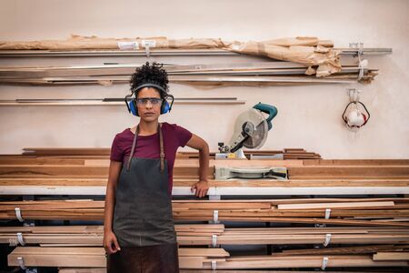Female artsian standing in her frame making workshop