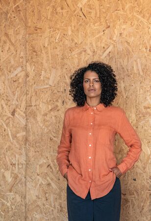 Aspirational young woman standing by a wall in her workshopの写真素材