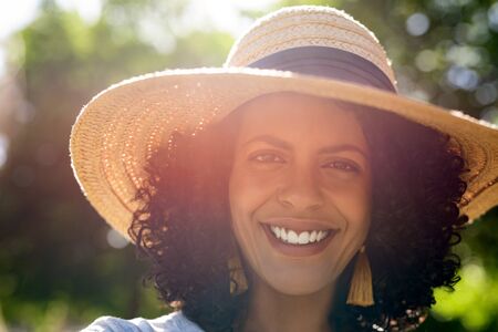Smiling young woman wearing a hat on a sunny dayの写真素材