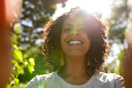 Laughing woman taking a selfie outside on a sunny dayの写真素材