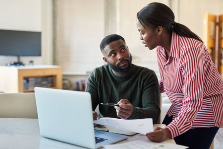 Young African American couple doing some online banking at homeの写真素材