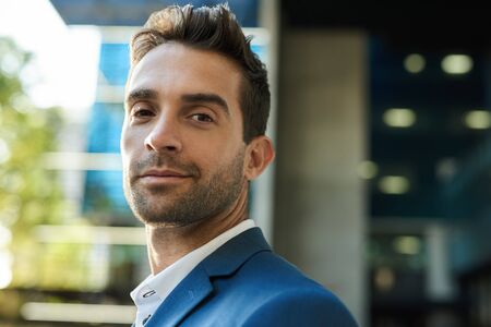 Businessman standing outside in the city on a sunny afternoonの写真素材