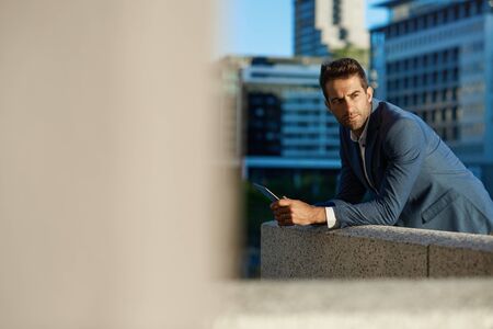 Businessman standing on an office terrace using a digital tabletの写真素材