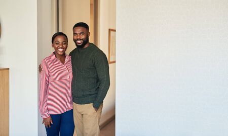 Smiling young African American couple standing together at homeの写真素材