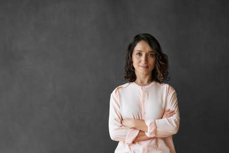 Young Asian businesswoman standing in front of a blank chalkboardの写真素材