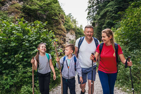 Smiling family of four hiking on a trail togetherの写真素材