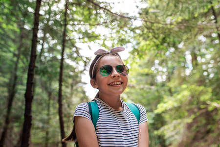 Cute little girl smiling while walking in a forestの写真素材