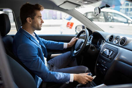 Man driving in a car along a street in the city