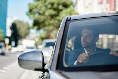 Young man driving his car through the city