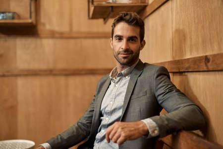 Stylish man in a blazer sitting in a trendy loungeの写真素材