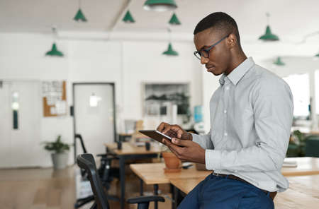 Young African businessman using a tablet at his office deskの写真素材