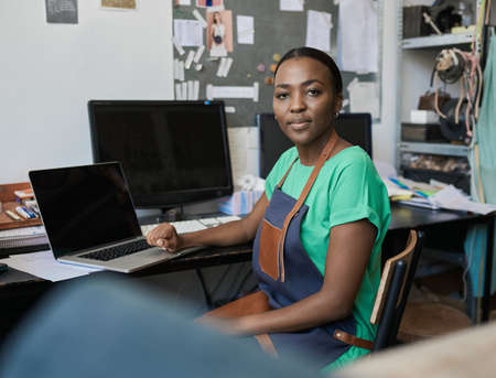 Young African female artisan working on a laptop in her studioの写真素材