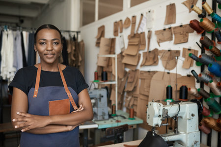 Young African female leather worker standing in her studioの写真素材