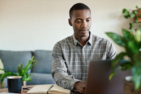 Young African businessman working remotely from homeの写真素材