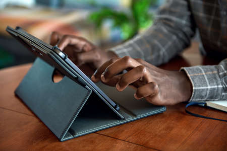 African businessman working from home using a digital tabletの写真素材