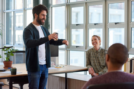 Young businessman talking with coworkers during a casual office meetingの写真素材