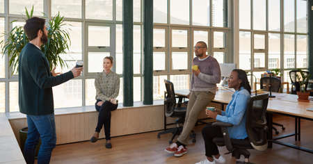 Young businessman talking with office colleagues during a casual meetingの写真素材