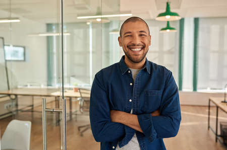 Young businessman laughing while standing in a modern office