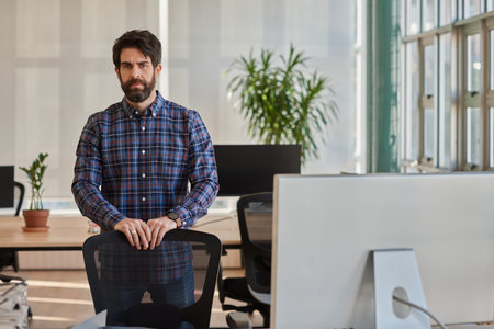 Focused businessman leaning on his chair in a modern officeの写真素材