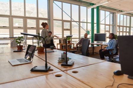 Businesswoman talking with diverse colleagues during a casual office meetingの写真素材