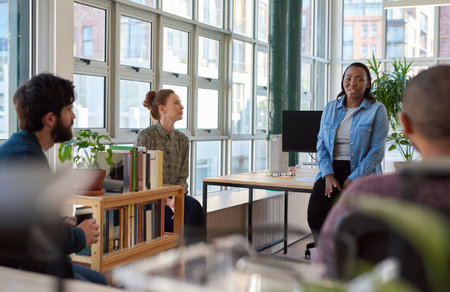 Smiling African businesswoman talking with colleagues during an office meetingの写真素材
