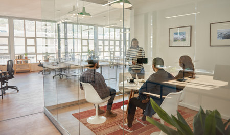 Young businesswoman doing a tablet presentation for colleagues in an officeの写真素材