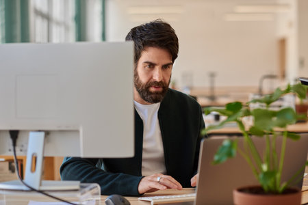Focused young businessman working on a laptop at his office deskの写真素材
