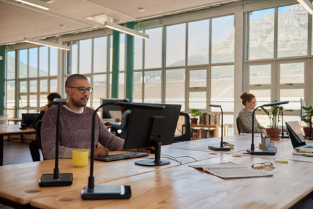 Young businessman and colleagues working in a large open plan officeの写真素材