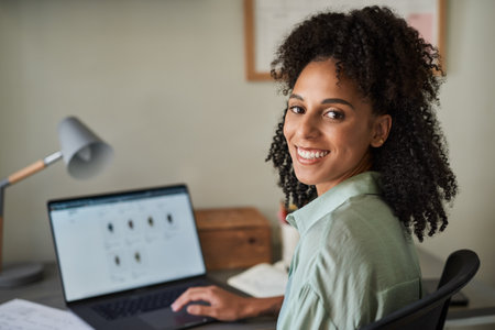 Smiling businesswoman using a laptop in her home officeの写真素材