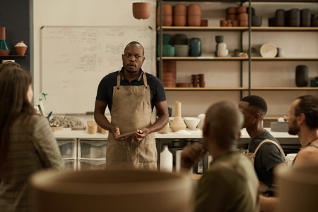 Diverse group of ceramists talking during a meeting in a studioの写真素材