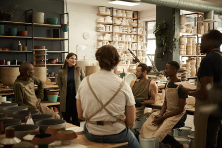 Smiling manager meeting with workers in a ceramics studioの写真素材