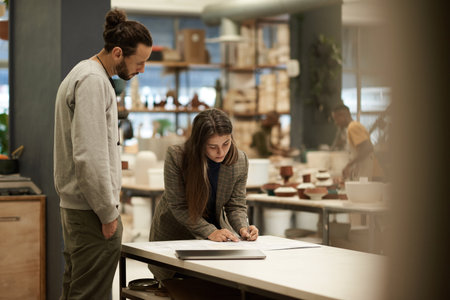 Ceramics studio owner and a worker going over ordersの写真素材