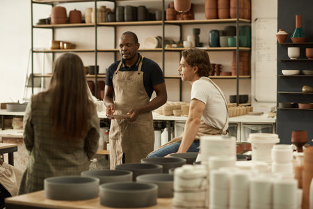 Diverse group of ceramists talking together in a studioの写真素材