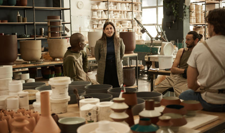 Smiling manager talking with workers in a ceramics studioの写真素材