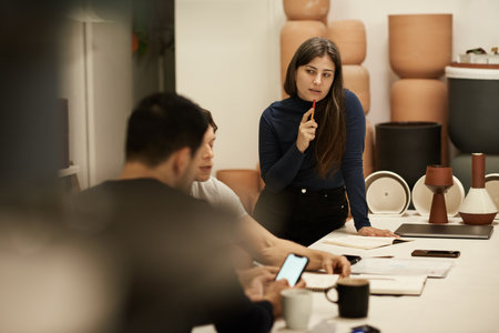 Ceramics designers talking together at a studio tableの写真素材