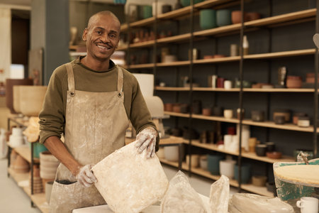 Smiling African ceramist making a mold in a pottery studioの写真素材
