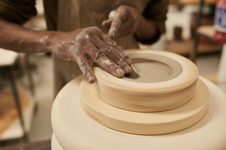 African ceramist working on clay turning in a mold on a pottery wheelの写真素材