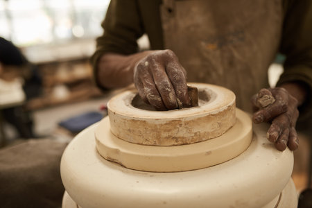 African ceramist molding clay on a pottery wheel in a studioの写真素材
