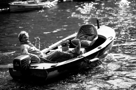 man on a boat in Amsterdam canal. Black and white. Netherlandsのeditorial素材