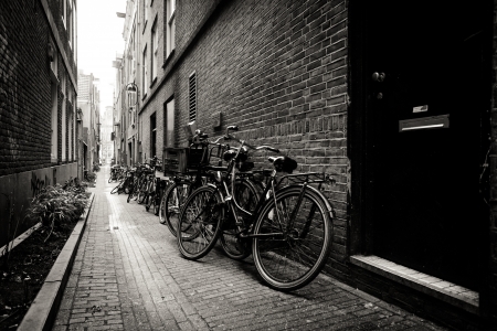 Old bicycles parked on a narrow street in Amsterdam. Black and white. Netherlandsのeditorial素材