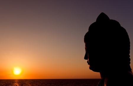 silhouette of buddha watching sunsetの写真素材