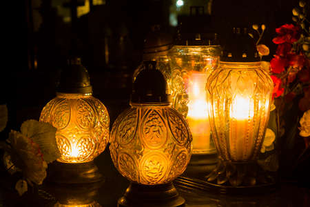 A beautiful composition of candles and flowers captured in the cemetery on a cloudless warm October night.の写真素材